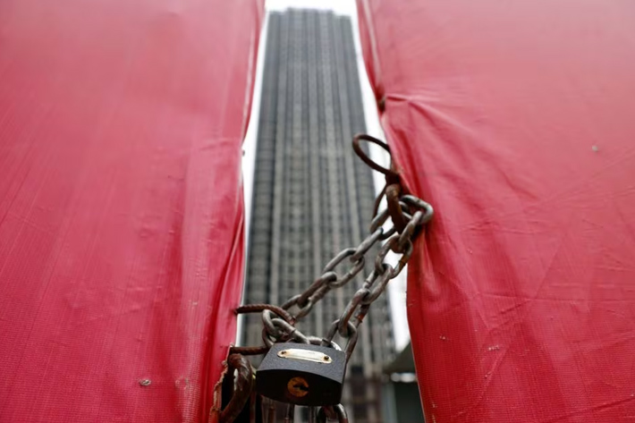 An unfinished residential building is pictured through a construction site gate at Evergrande Oasis, a housing complex developed by Evergrande Group, in Luoyang, China