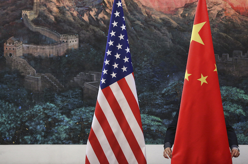 A Chinese man adjusts a China flag before a news conference attended by Chinese Foreign Minister Yang Jiechi and US Secretary of State Hillary Clinton at the Great Hall of the People in Beijing