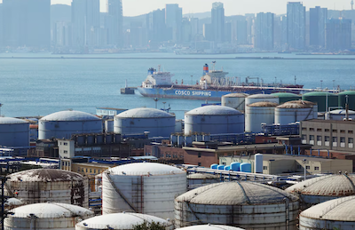 A China Ocean Shipping Company (COSCO) vessel is seen near oil tanks at the China National Petroleum Corporation (CNPC)'s Dalian Petrochemical Corp in Dalian, Liaoning province, China October 15, 2019. REUTERS/Stringer/File photo Purchase Licensing Rights